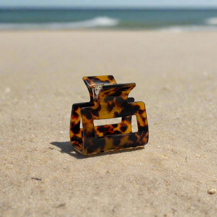 tortoiseshell rectangular hair claw clip made from plant-based cellulose acetate, on beach