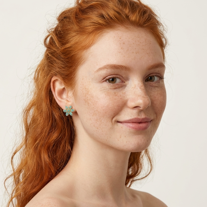 Model wearing Cecilia gold vermeil floral stud earrings with Blue Topaz Zircon brilliants.