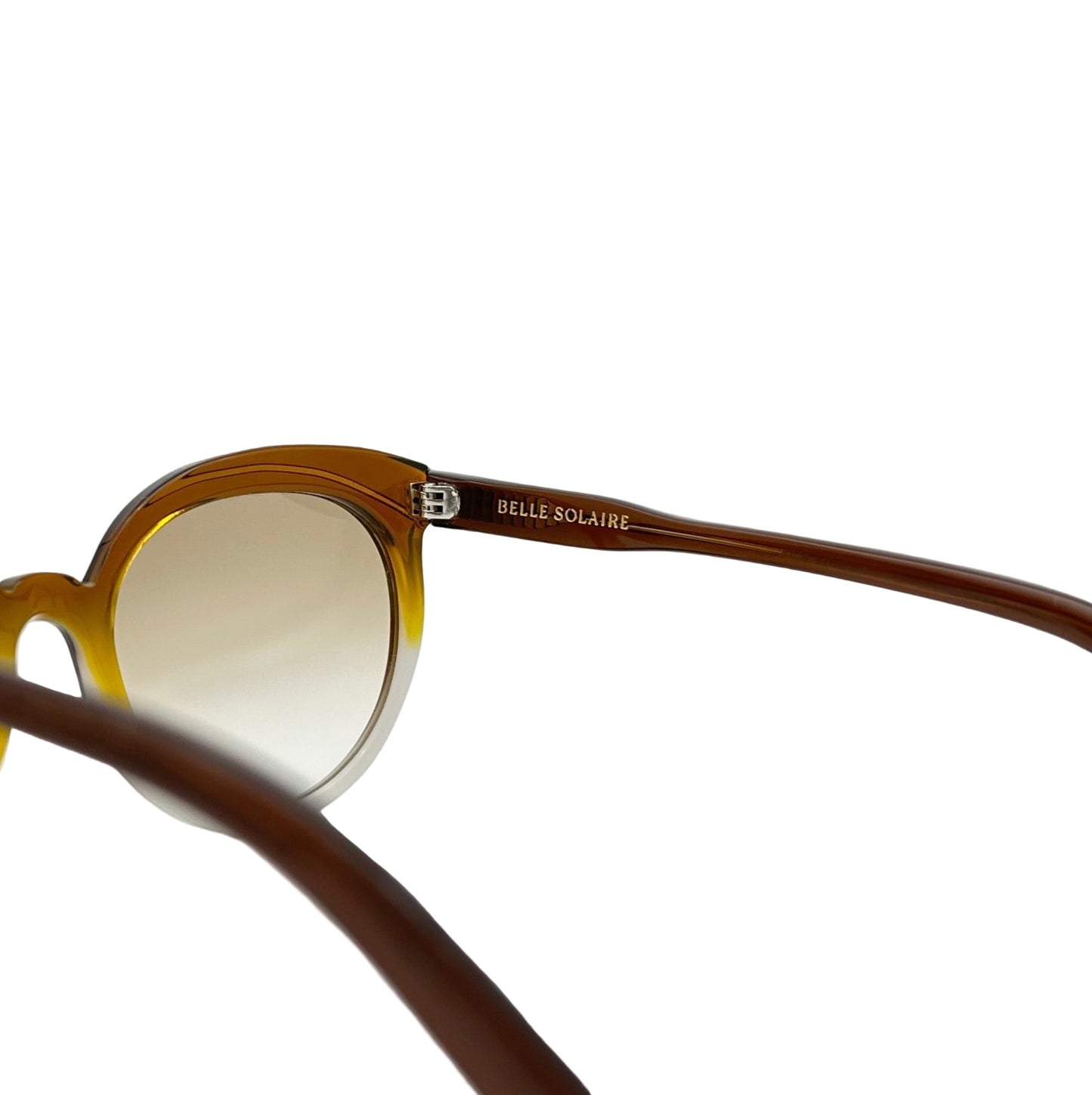 Close-up of the inside of brown cat-eye sunglasses showing the logo on white background