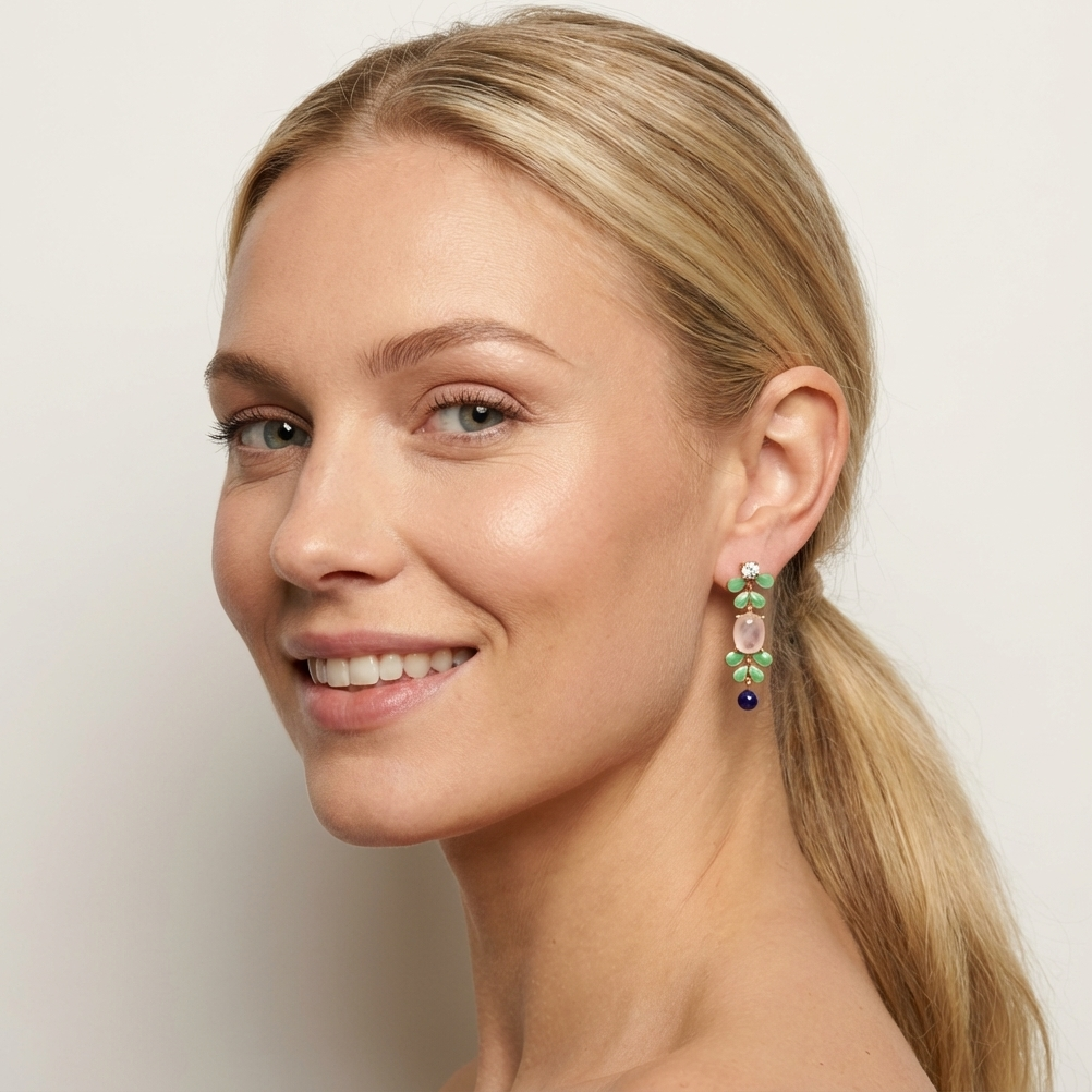 Model wearing Seraphine gold vermeil earrings with enameled leaf design and Rose Quartz gemstone.
