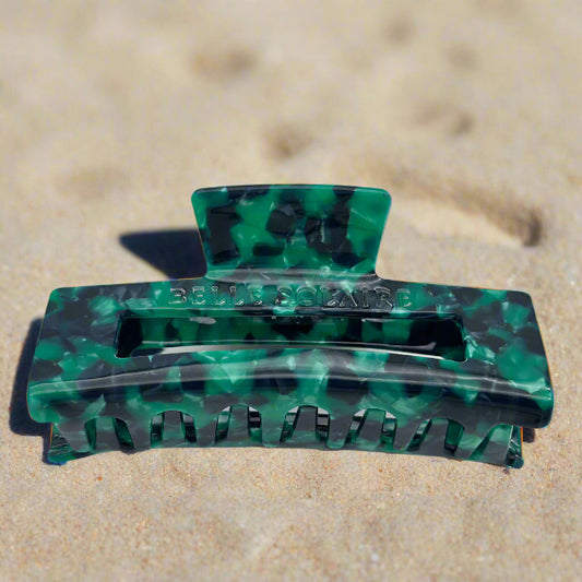 Close-up of the Emerald Grove hair clip featuring deep emerald green with touches of dark teal and smoky black showing the inner claws.