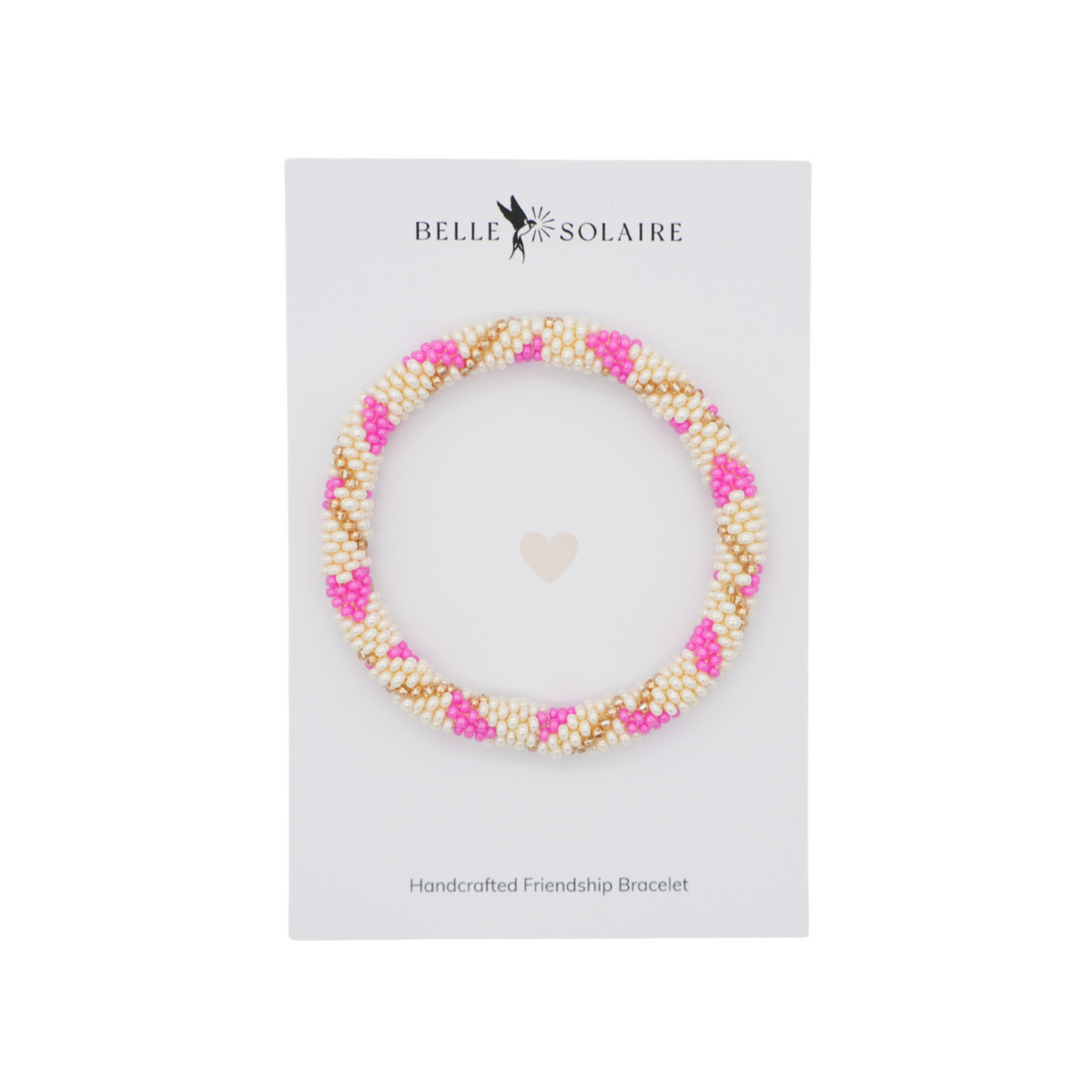 A handcrafted friendship bracelet by Belle Solaire, featuring a braided pattern of white faux pearls, bright pink beads, and gold beads, presented on a white display card.