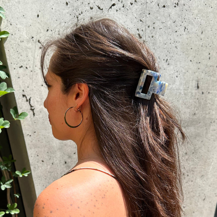 Model wearing the Indigo Bloom clip outdoors, styled in long hair for a chic and nature-inspired everyday look.