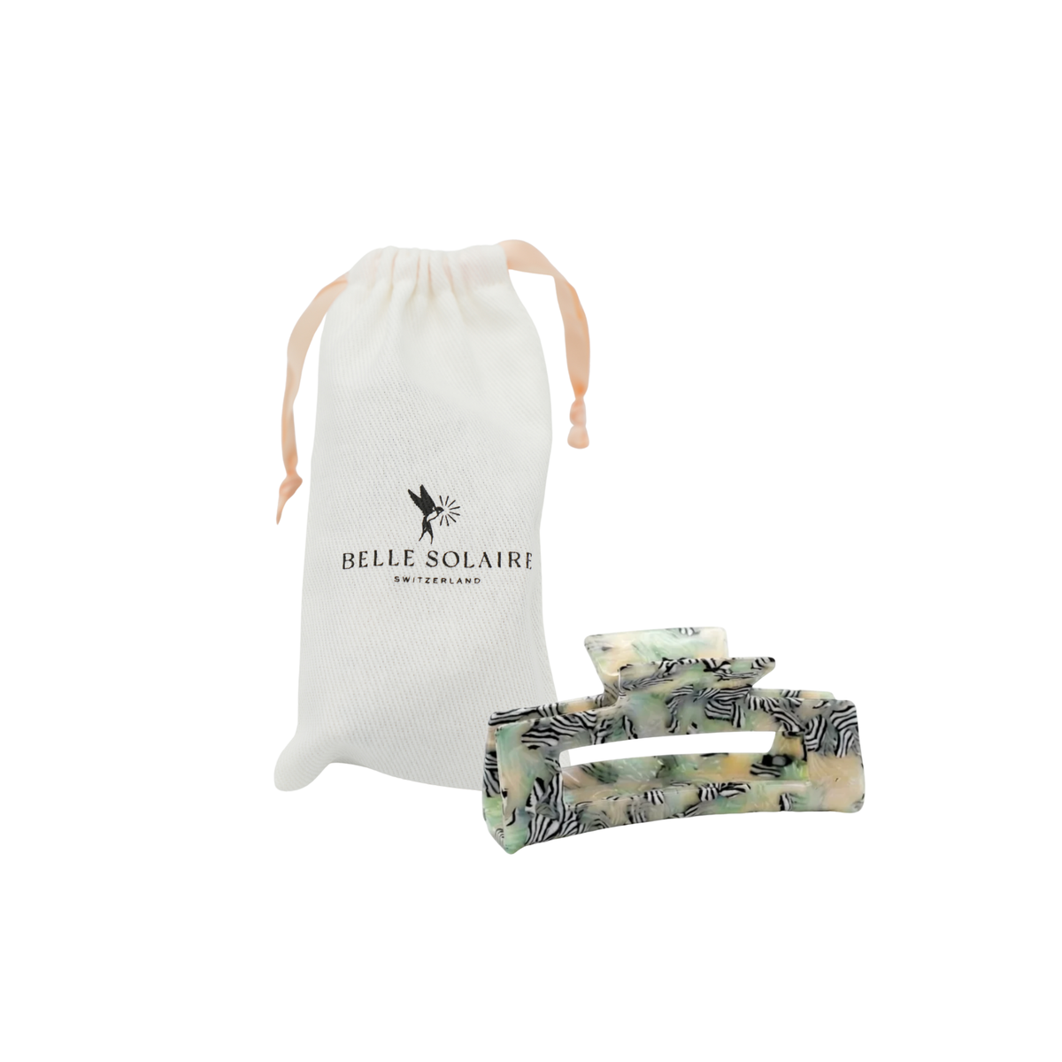 A hair claw clip with a zebra print pattern in black, white, and pale green, shown next to its white drawstring storage pouch featuring the 'BELLE SOLAIRE SWITZERLAND' logo, on a solid white background.