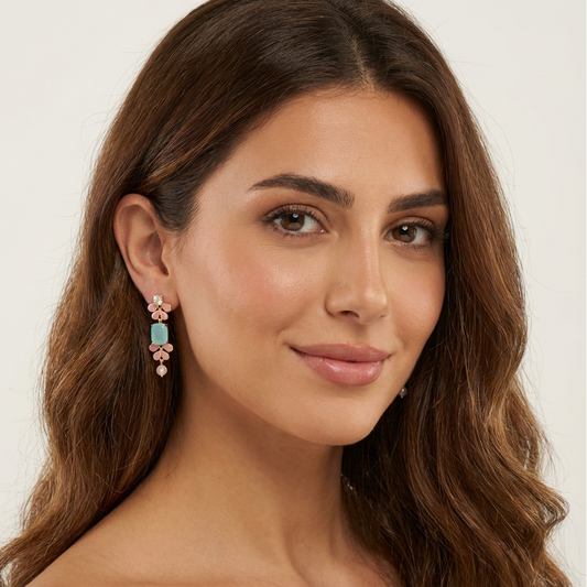 Model wearing Seraphine gold vermeil earrings with enameled leaf design and Aqua Chalcedony gemstone.